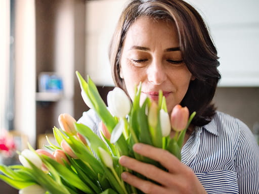 Woman smiling as she holds a bouquet of tulips