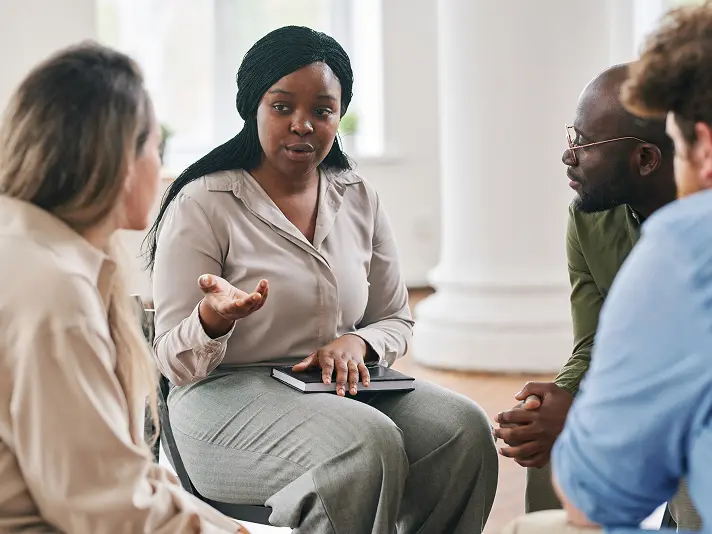 Therapist leading a small group therapy session in an intensive outpatient program