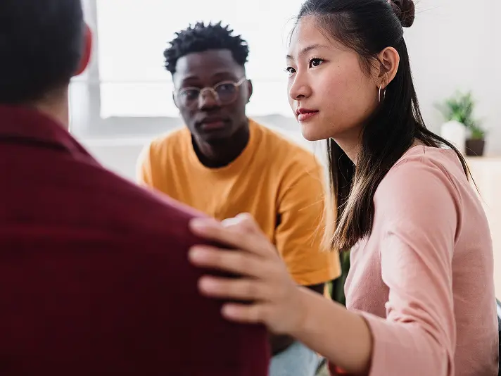 Young woman comforting a peer during a group session in a partial hospitalization program